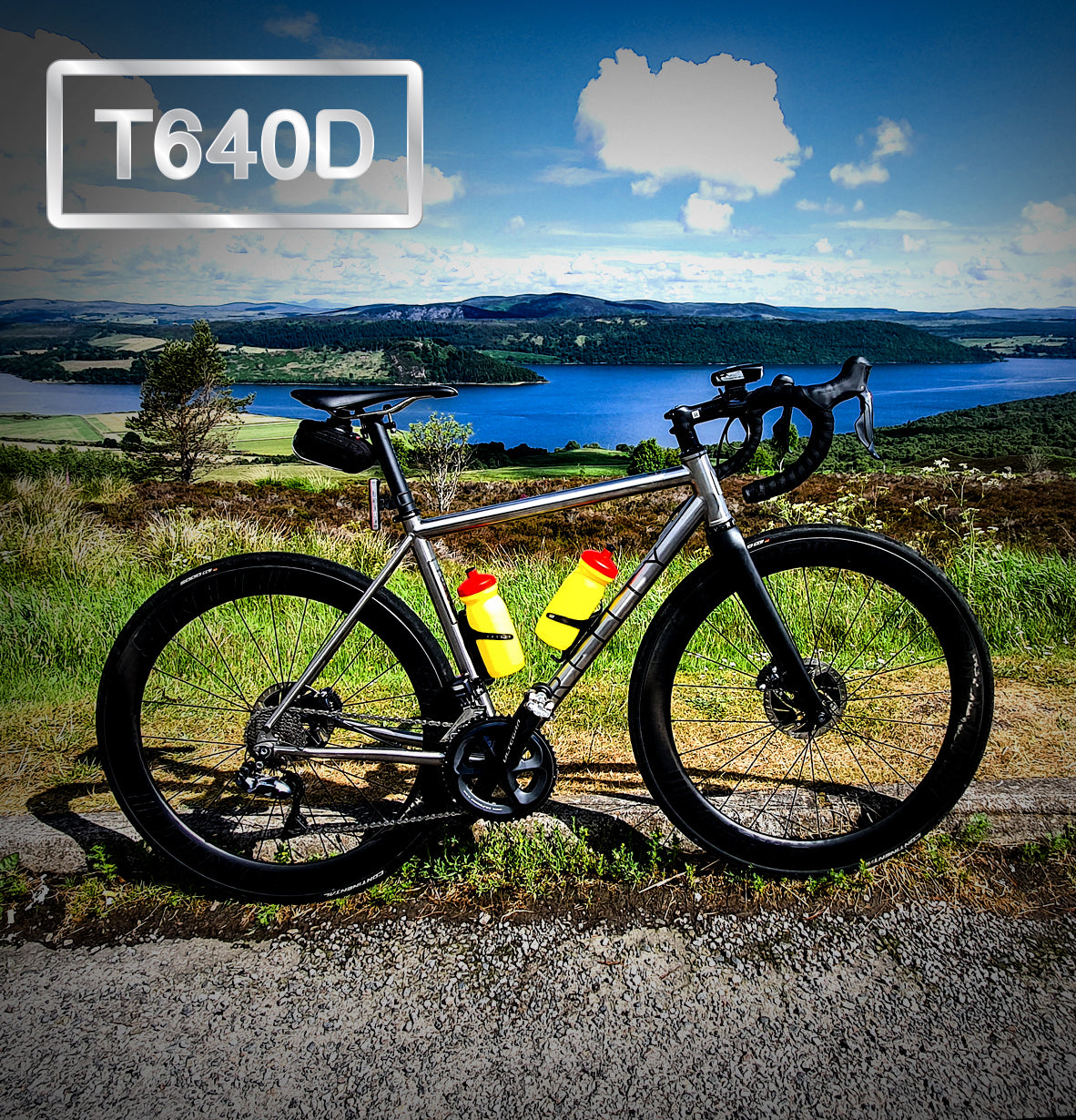 Road Bike in the foreground with beautiful green landscape and lake in the background. T640D is written top left.