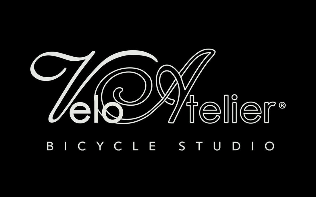 Velo Atelier in cursive font in white on a black background. 