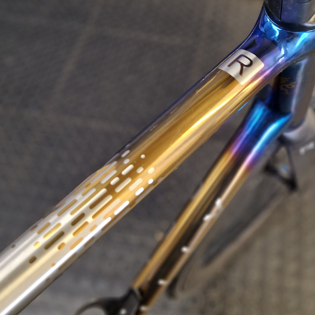 anodised top tube with gold design to blue with R logo 