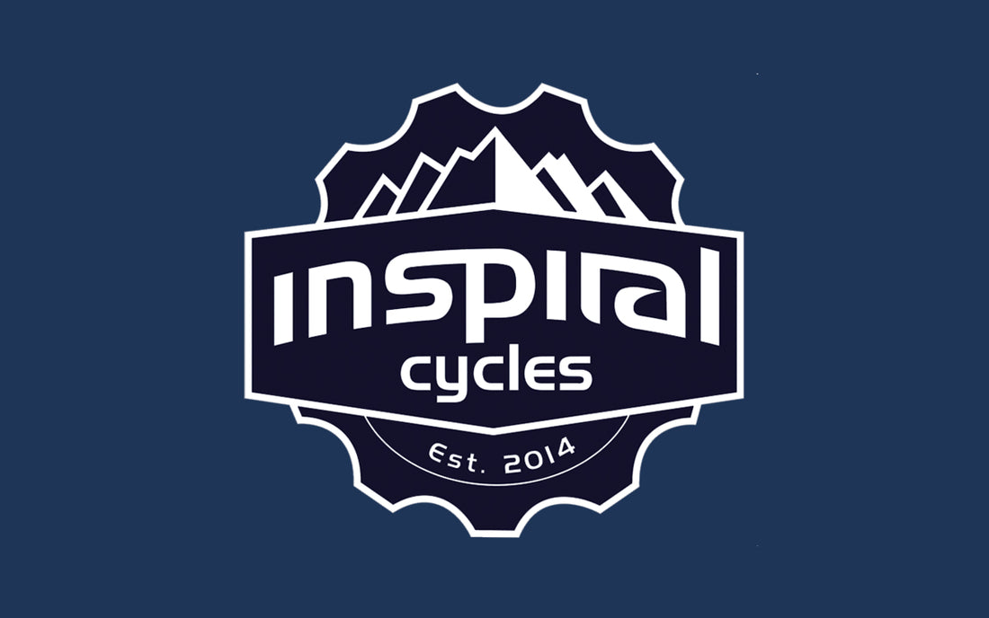 Inspiraal Cycles with a mountain range drawn in the background encompased in a cog shape.