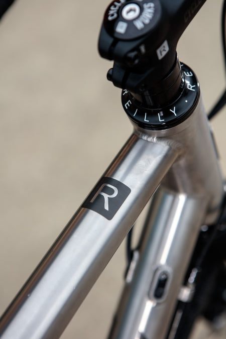 Brushed titanium top tube with R logo in black.